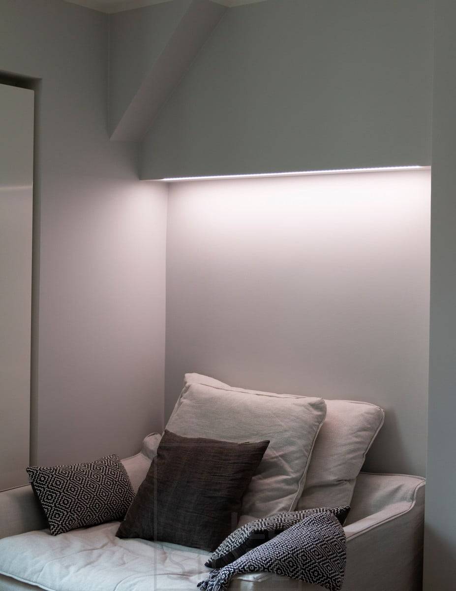 Bonita iluminación ambiental sobre la cama en el dormitorio. Iluminación indirecta regulable en temperatura de color.